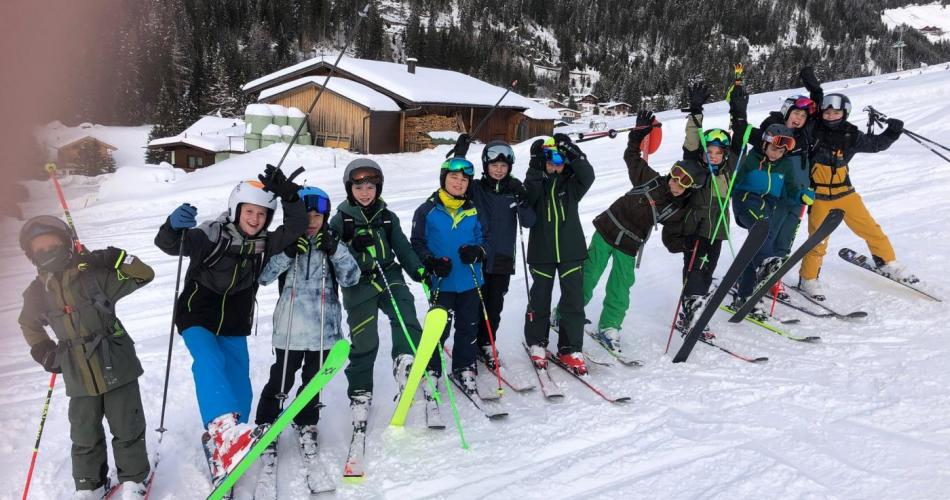 Die Skifahrer der 1. Klassen posieren im Schnee.