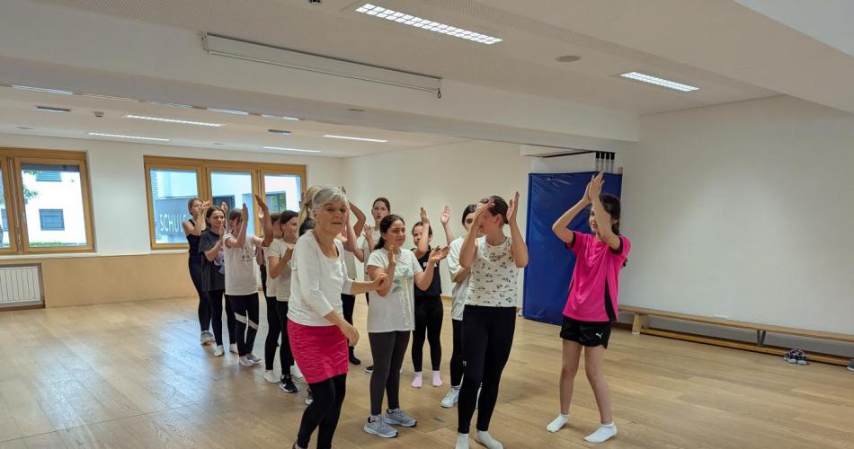 Die Mädchen der ersten Klassen stehen in einer Zweierreihe, um Polonaise zu tanzen.